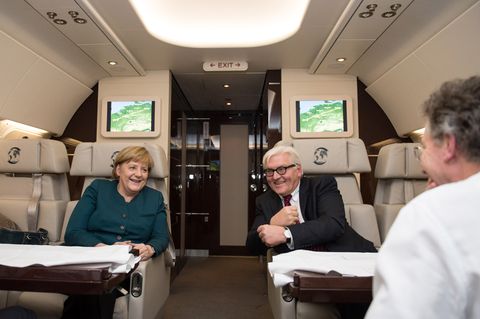 Bundeskanzlerin Angela Merkel (l.) und Außenminister Frank-Walter Steinmeier unterhalten sich auf dem Rückflug von Paris am 18.12.2013 nach dem Antrittsbesuch beim französischen Präsidenten