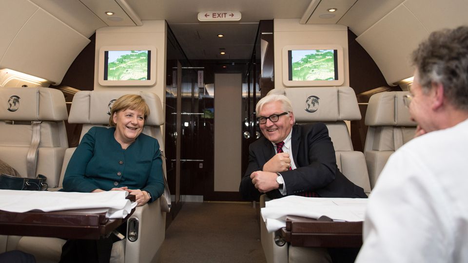 Bundeskanzlerin Angela Merkel (l.) und Außenminister Frank-Walter Steinmeier unterhalten sich auf dem Rückflug von Paris am 18.12.2013 nach dem Antrittsbesuch beim französischen Präsidenten