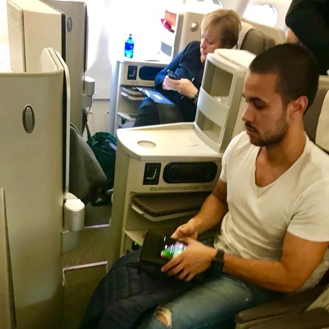 Im Linienflieger: Der Argentinier Agustín Agüero sitzt während des Iberia-Flugs von Madrid nach Buenos Aires neben Bundeskanzlerin Angela Merkel.