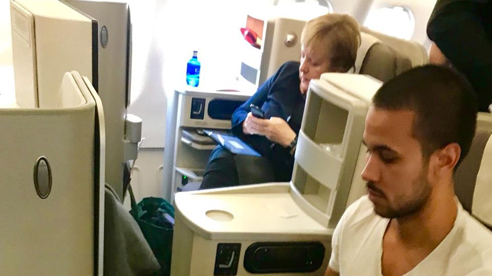 Im Linienflieger: Der Argentinier Agustín Agüero sitzt während des Iberia-Flugs von Madrid nach Buenos Aires neben Bundeskanzlerin Angela Merkel.