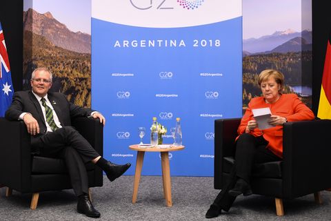 Angela Merkel informiert sich über Scott Morrison, während dieser schon neben ihr sitzt