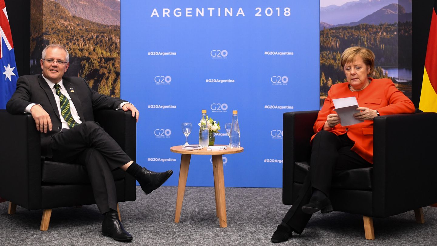 Angela Merkel informiert sich über Scott Morrison, während dieser schon neben ihr sitzt