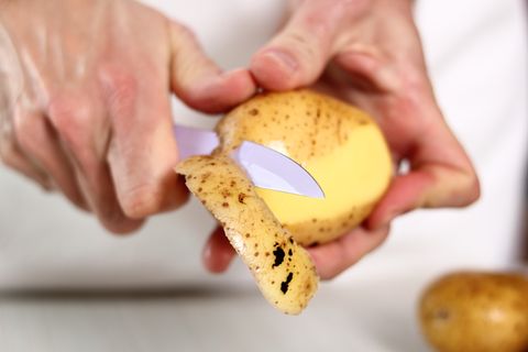 Ein mann schält eine Kartoffel