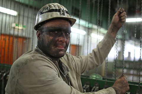 Ein Bergmann mit Helm steht in einem Steinkohlebergwerk