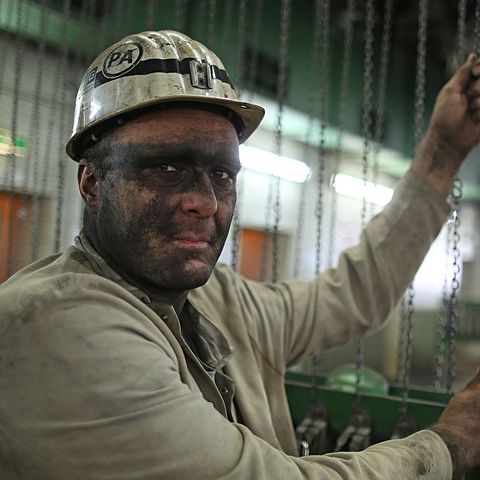Ein Bergmann mit Helm steht in einem Steinkohlebergwerk