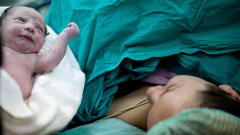 Mutter mit Neugeborenem im OP nach einem Kaiserschnitt