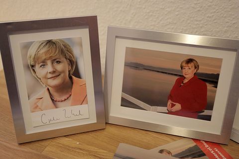 Wer ist die echte Angela Merkel? Neben einer Autogrammkarte der Bundeskanzlerin (l.) hat sich  Ursula Wanecki ein Foto von sich selbst auf ihren Schreibtisch gestellt.