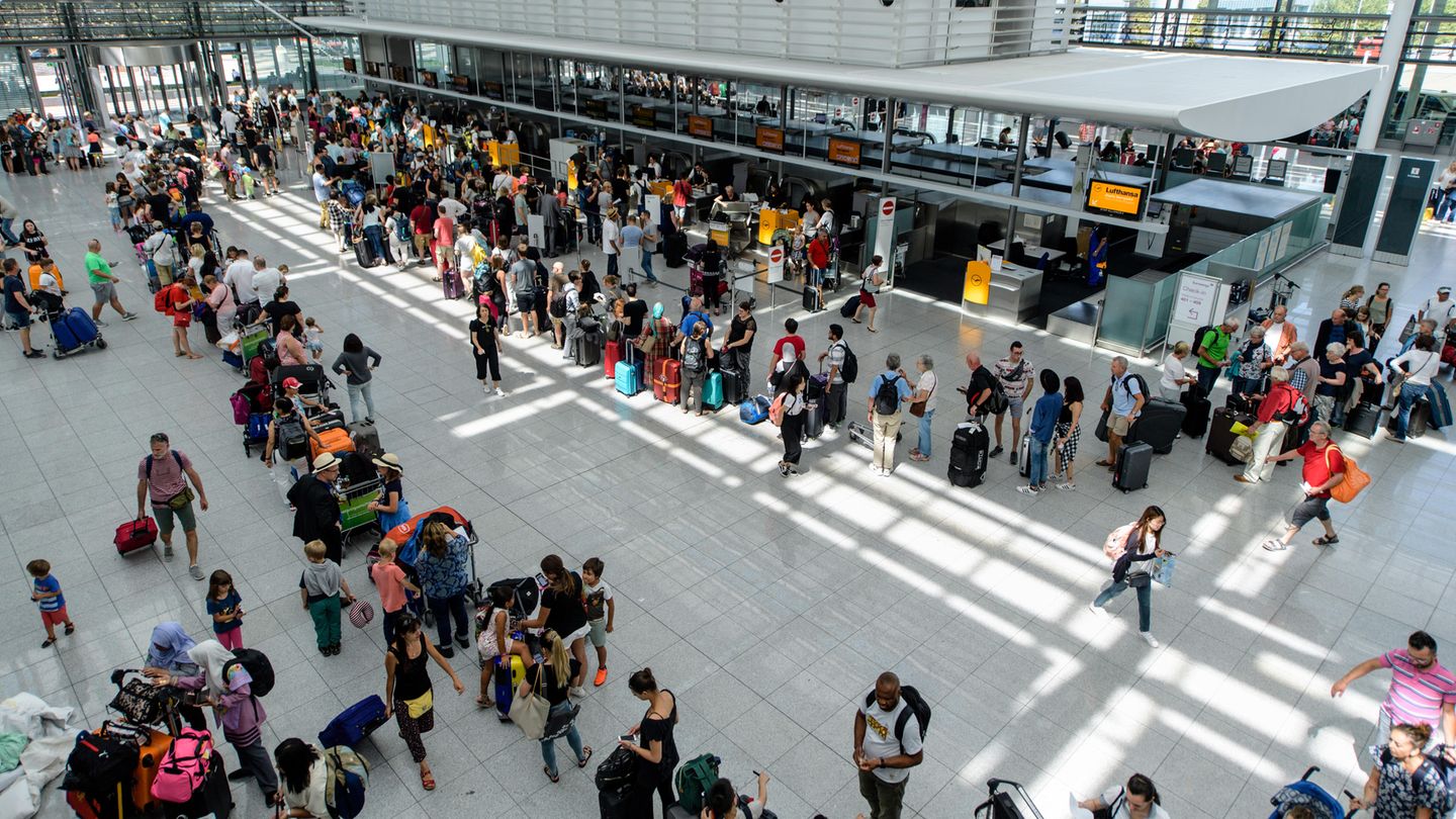 Lange Warteschlangen am Flughafen München: Fluggäste stehen  an Check-In-Schaltern im Terminal 2