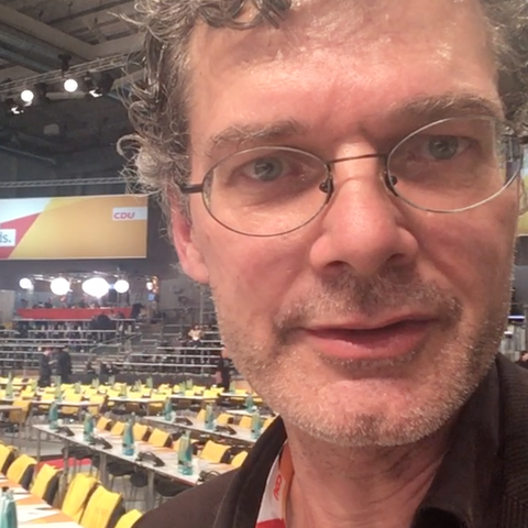 stern-Reporter Tilman Gerwien steht in der Halle des CDU-Parteitags 2018 in Hamburg vor noch leeren Stuhlreihen