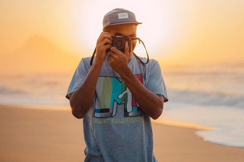 Fotograf mit Kamera am Strand