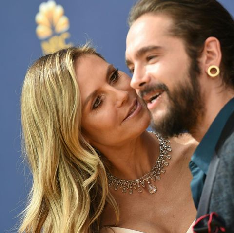 Heidi Klum schaut ihren Freund Tom Kaulitz von der Seite an, während die beiden auf einem roten Teppich posieren