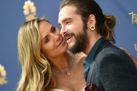 Heidi Klum schaut ihren Freund Tom Kaulitz von der Seite an, während die beiden auf einem roten Teppich posieren