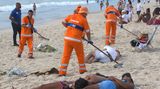 Leute schlafen am 01.01.2018 in Copacabana während die Müllmänner den Müll von den Silvester-Feierlichkeiten aufräumen
