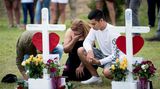 Santa Fe, USA. Fassungslos kniet ein Paar vor zwei Holzkreuzen auf dem Gelände der Santa Fe High School. Ein Amokläufer war drei Tage zuvor zu Unterrichtsbeginn mit einem Sturmgewehr und einem Revolver in seine Schule gekommen und hatte dort um sich geschossen. Bei dem Blutbad wurden zehn Menschen getötet und 13 weitere verletzt.