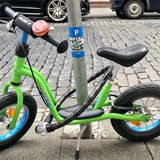 Wiesbaden, Deutschland. Man muss nur einfallsreich sein: Jemand hat das Laufrad eines Kindes an einen Laternenmast angekettet. An dem Mast wurde ein Aufkleber angebracht, der ein angekettetes hellgrünes Laufrad für Kleinkinder zeigt. Über dem Foto steht auf blauem Grund ein weißes P - darunter das Wort "only" - nur.  