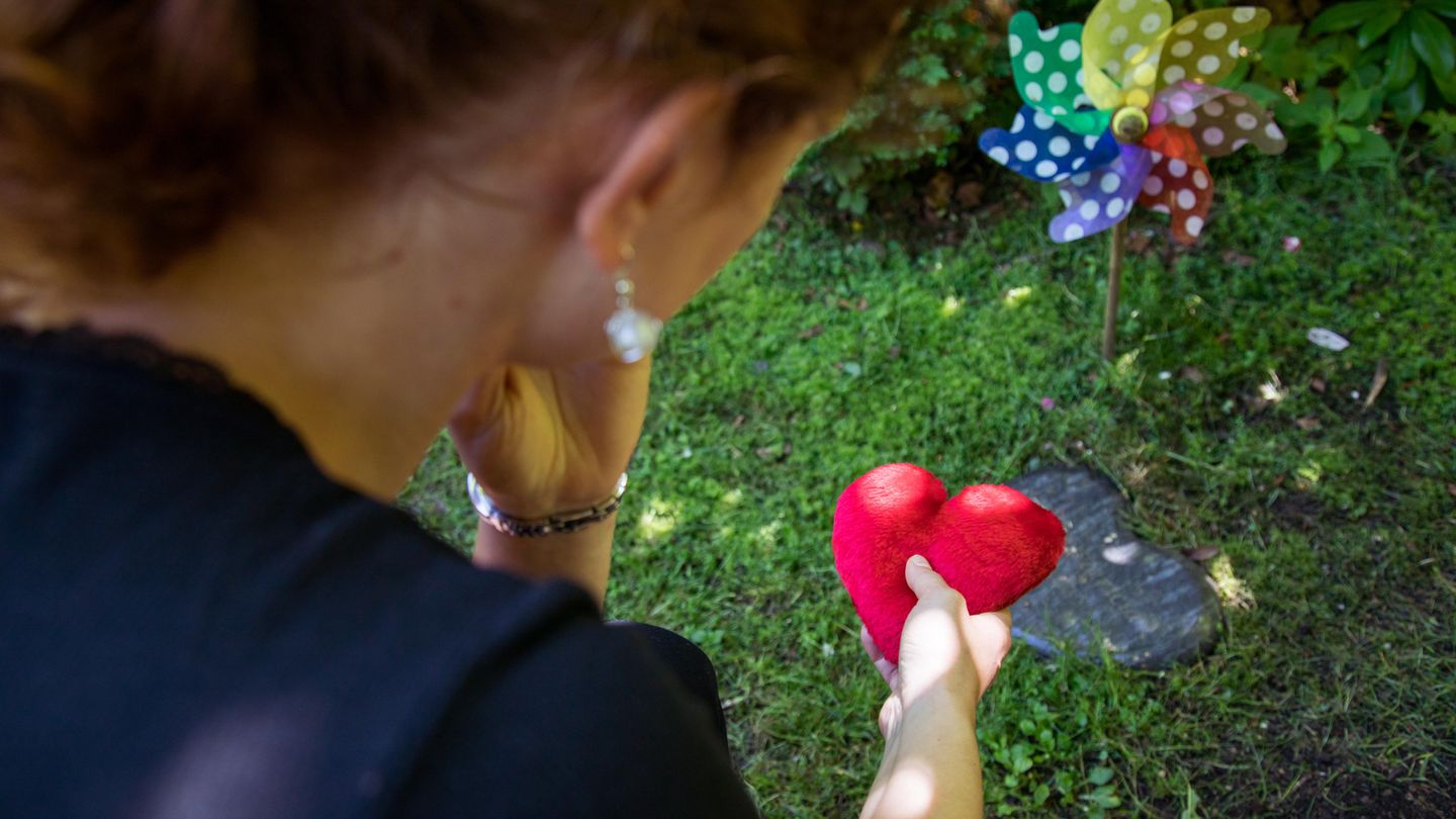 Eine trauernde Mutter am Grab ihres Kindes