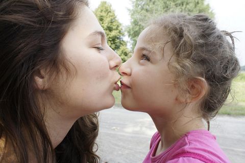 Eine Mutter will ihre kleine Tochter küssen