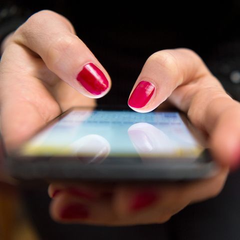 Frau, die ein Handy in der Hand hält