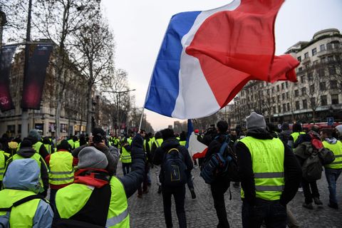 "Gelbwesten" schwenken eine Frankreich-Flagge bei Protesten