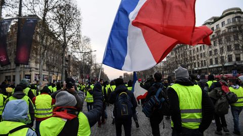 "Gelbwesten" schwenken eine Frankreich-Flagge bei Protesten