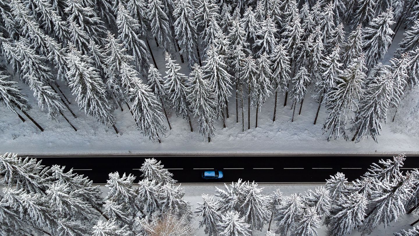 Auto fährt durch Winterlandschaft