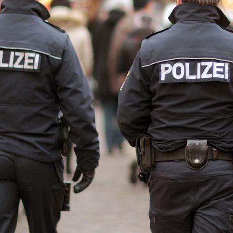 Zwei Polizeibeamte laufen auf dem Weihnachtsmarkt in Frankfurt am Main Streife. 