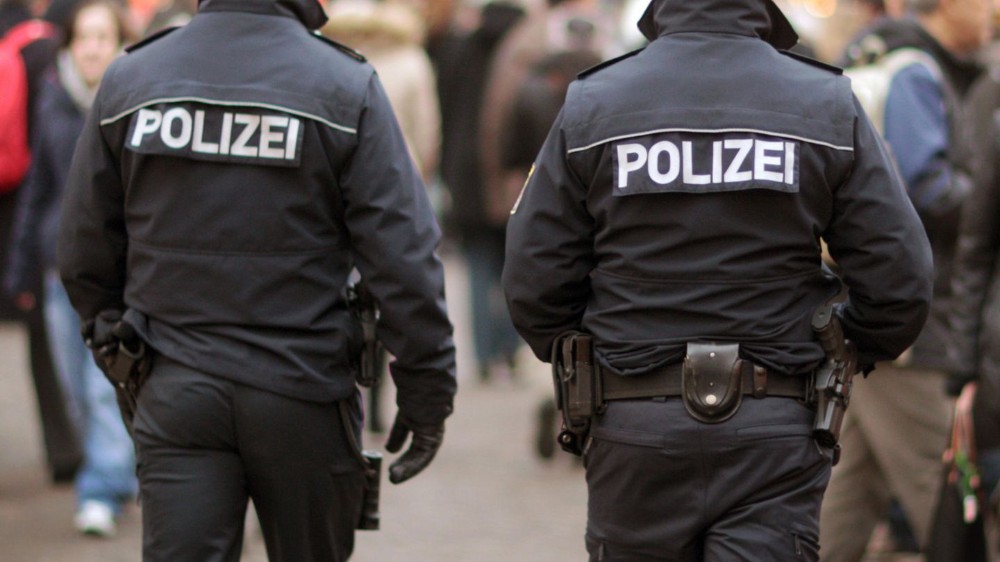 Zwei Polizeibeamte laufen auf dem Weihnachtsmarkt in Frankfurt am Main Streife. 