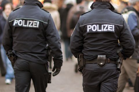 Zwei Polizeibeamte laufen auf dem Weihnachtsmarkt in Frankfurt am Main Streife. 