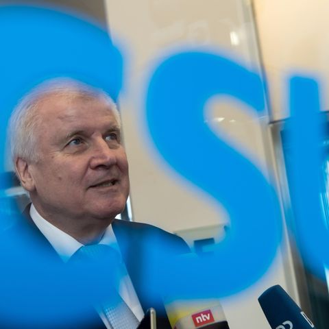 Auf einer Glasscheibe steht ein blauer CSU-Schriftzug. Durch das C ist dahinter Horst Seehofers Gesicht zu sehen