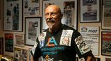 Mr. Hayabusa, der Rekordjäger, vor Zeitungsausschnitten und Urkunden an seiner Heldenwand