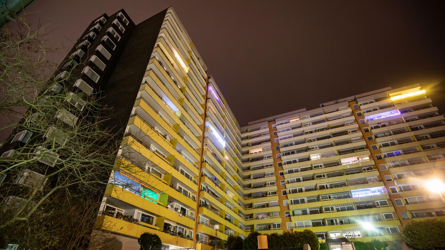 Im Dunkeln ragt das L-förmige Hochhaus in Heidelberg in die Höhe, viele Fenster sind dunkel, aus anderen scheint Licht
