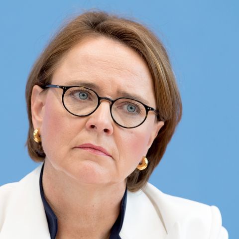 Die Integrationsbeauftragte der Bundesregierung, Annette Widmann-Mauz, legt vor einer hellblauen Wand den Kopf schräg
