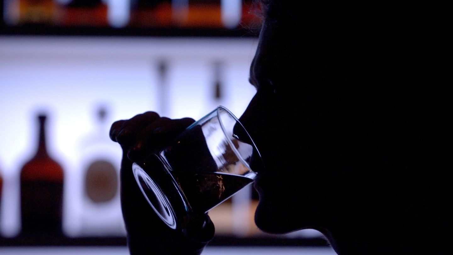 Ein Mann trinkt Alkohol aus einem Glas
