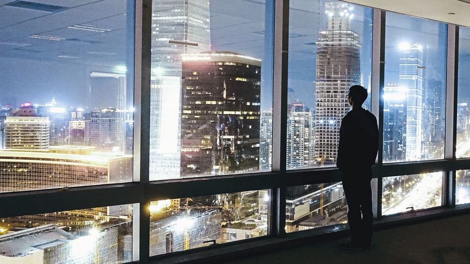 Globalisierung: Ein Mann blickt auf die abendlich erleuchteten Wolkenkratzer in Peking. Wie die Hauptstadt haben sich alle größeren Städte Chinas in nur wenigen Jahren zu glitzernden modernen Metropolen entwickelt. Ein Mann blickt auf die abendlich erleuchteten Wolkenkratzer in Peking. Wie die Hauptstadt haben sich alle größeren Städte Chinas in nur wenigen Jahren zu glitzernden modernen Metropolen entwickelt.