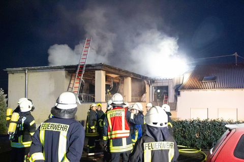 Feuerwehrleute stehen vor einem brennenden Wohnhaus in Freudenburg.