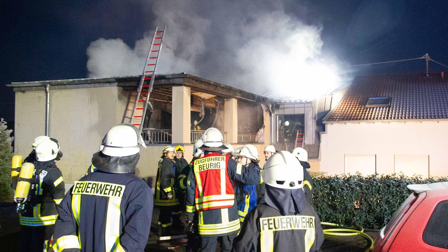 Feuerwehrleute stehen vor einem brennenden Wohnhaus in Freudenburg.