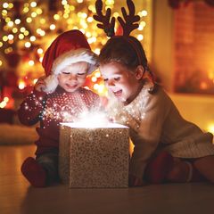Kinder packen ein Weihnachtsgeschenk aus