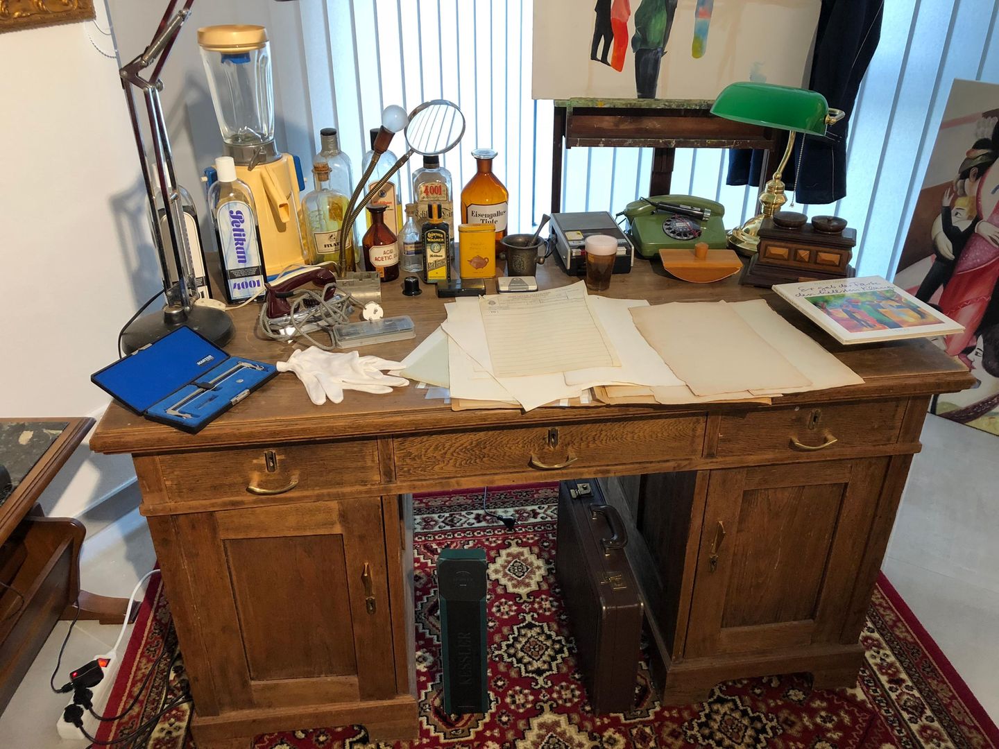 "Faking Hitler": Ein Schreibtisch mit Kujaus Fälscherutensilien: Hinten links steht ein hoher Mixer zum Anrühren von Tinte, Rezeptur nach Gusto mit schwarzer und blauer Pelikan-Tinte (ebenfalls links auf dem Schreibtisch). Kujau musste immer andere Tintenfarben benutzen, damit die Tagebücher authentischer aussahen - als wären sie über Jahre hinweg geschrieben worden. Der Mixer stammt aus den 50er Jahren, er ist das einzige Modell, das vorne einen Ausguss hatte. Davor wurde ein Glas gestellt, in das die angemischte Tinte hineinlief und in das dann die Schreibfeder eingetaucht wurde. Kujau verwendete eine Stahlfeder in einem Federhalter. Um die Tagebuchseiten alt aussehen zu lassen, hat Kujau das Papier mit schwarzem Tee vergilbt und dann mit dem Bügeleisen gebügelt, damit das Papier schön glatt ist. Der Schreibtisch selbst gehörte nicht Kujau. Ein Schreibtisch mit Kujaus Fälscherutensilien: Hinten links steht ein hoher Mixer zum Anrühren von Tinte, Rezeptur nach Gusto mit schwarzer und blauer Pelikan-Tinte (ebenfalls links auf dem Schreibtisch). Kujau musste immer andere Tintenfarben benutzen, damit die Tagebücher authentischer aussahen - als wären sie über Jahre hinweg geschrieben worden. Der Mixer stammt aus den 50er Jahren, er ist das einzige Modell, das vorne einen Ausguss hatte. Davor wurde ein Glas gestellt, in das die angemischte Tinte hineinlief und in das dann die Schreibfeder eingetaucht wurde. Kujau verwendete eine Stahlfeder in einem Federhalter. Um die Tagebuchseiten alt aussehen zu lassen, hat Kujau das Papier mit schwarzem Tee vergilbt und dann mit dem Bügeleisen gebügelt, damit das Papier schön glatt ist. Der Schreibtisch selbst gehörte nicht Kujau.