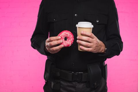 Ein us-amerikanischer Polizist mit Donuts und Kaffee