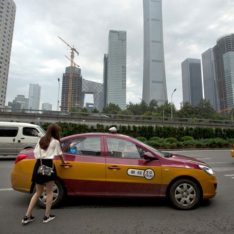 Eine Frau steigt in ein Taxi, aufgenommen in China
