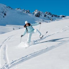 Eine Frau fährt ungelenk Ski