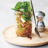 Soba-Nudeln mit Tofu, Ingwer & Zuckererbsen      Zutaten:  40 g Soba-Nudeln (japani­sche Buchweizennudeln), 100 g Zuckerschoten, geputzt und in Streifen geschnitten, 80 g marinierter Tofu, geba­cken und in Streifen geschnitten, ¼ rote Paprikaschote, geputzt und in feine Streifen geschnitten, 50 g abgepackte asiatische Blattsalatmischung oder Baby-Spinat, 2 Teelöffel salzreduzierte Sojasauce, 1 Teelöffel Mirin (Reiswein), ½ Teelöffel fein geriebener, frischer Ingwer      Zubereitung:  Wasser in einem mittelgroßen Topf bei starker Hitze zum Kochen bringen und die Soba-Nudeln darin nach Packungsanweisung bissfest garen. In den letzten 30 Sekunden die Zuckerschoten zugeben. Nudeln und Zuckerschoten in ein Sieb abgießen und mit kaltem Wasser abschrecken.      Nudeln, Zuckerschoten, Tofu, Paprika und Blattsalate in einer Portions-Salatschüssel oder in einem Glas (siehe Abbildung rechts) mischen. Sojasauce, Mirin und Ingwer darüber verteilen, vorsichtig unterheben und servieren.