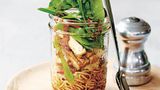 Soba-Nudeln mit Tofu, Ingwer & Zuckererbsen      Zutaten:  40 g Soba-Nudeln (japani­sche Buchweizennudeln), 100 g Zuckerschoten, geputzt und in Streifen geschnitten, 80 g marinierter Tofu, geba­cken und in Streifen geschnitten, ¼ rote Paprikaschote, geputzt und in feine Streifen geschnitten, 50 g abgepackte asiatische Blattsalatmischung oder Baby-Spinat, 2 Teelöffel salzreduzierte Sojasauce, 1 Teelöffel Mirin (Reiswein), ½ Teelöffel fein geriebener, frischer Ingwer      Zubereitung:  Wasser in einem mittelgroßen Topf bei starker Hitze zum Kochen bringen und die Soba-Nudeln darin nach Packungsanweisung bissfest garen. In den letzten 30 Sekunden die Zuckerschoten zugeben. Nudeln und Zuckerschoten in ein Sieb abgießen und mit kaltem Wasser abschrecken.      Nudeln, Zuckerschoten, Tofu, Paprika und Blattsalate in einer Portions-Salatschüssel oder in einem Glas (siehe Abbildung rechts) mischen. Sojasauce, Mirin und Ingwer darüber verteilen, vorsichtig unterheben und servieren.