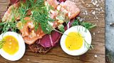 Offenes Sandwich mit Lachs, Ingwer & Limette      Zutaten:  120 g Lachsfilet in Sushi-Qualität, dünn quer zur Fleischfaser geschnitten Salz und frisch gemahlener schwarzer Pfeffer 1 Teelöffel fein gehackter frischer Ingwer abgeriebene Schale und frisch gepresster Saft von 1 Bio-Limette 1 Scheibe Roggenvollkornbrot oder Pumpernickel, getoastet 3 bittere Salatblätter, z. B. Radicchio 1 Ei (Größe L), hart gekocht und halbiert frische Dillspitzen zum Servieren      Zubereitung:  Den Lachs auf einen Teller legen, mit etwas Salz und Pfeffer würzen. Den Fisch mit Ingwer und Limettenschale bestreuen, mit Limettensaft beträufeln.