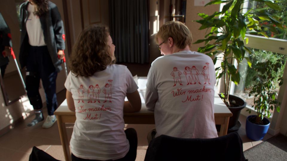 Bildung: Alle Betreuer tragen weiße T-shirts mit der Aufschrift: "Wir machen Mut". Alle Betreuer tragen weiße T-shirts mit der Aufschrift: "Wir machen Mut".