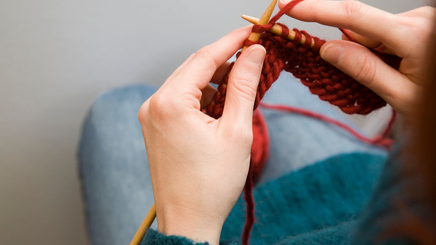 Eine Frau strickt. Zum Thema: Verspätungsschal wird im Internet versteigert