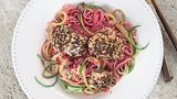 Zoodles in Rote-Bete-Pesto mit Hähnchennuggets      Zutaten:  Für das Rote-Bete-Pesto: 2 kleine frische Knollen Rote Bete (à ca. 75 g), Salz, 10 g Pinienkerne, 1 Knoblauchzehe, 15 g Parmesan, ½ unbehandelte Orange, 1–2 EL Olivenöl, frisch gemahlener schwarzer Pfeffer  Für die Zoodles: 1 große Zucchini, 100 g Dinkel-Spaghetti, Salz  Für die Hähnchennuggets: 1 Hähnchenfilet (ca. 150 g), Salz, frisch gemahlener schwarzer Pfeffer, 1 kleines Ei (Größe S), 1 EL Dinkelmehl Type 1050, 1 Scheibe Pumpernickel (ca. 42 g), 1 TL Sesamsamen, 1 EL Olivenöl zum Braten      Zubereitung:  Für das Rote-Bete-Pesto die Rote Bete in kochendem Salzwasser in etwa  50 Minuten weich garen. Abgießen, etwas abkühlen lassen und grob würfeln.  Die Pinienkerne in einer kleinen beschichteten Pfanne ohne Fett  goldgelb anrösten, herausnehmen und auskühlen lassen. Den Knoblauch  abziehen und grob hacken. Den Parmesan ebenfalls grob hacken.  Die Orange fein abreiben, 4–5 EL Saft auspressen, beides mit der Roten  Bete, den Pinienkernen, dem Knoblauch, dem Parmesan und dem Olivenöl  in einen hohen Rührbecher geben und mit dem Mixstab fein pürieren. Das  Pesto mit dem Salz und dem Pfeffer abschmecken.  Für die Zoodles die Zucchini waschen und mit einem Spiralschneider zu  Zucchini-Spaghetti schneiden. Die Dinkel-Spaghetti in reichlich kochendem  Salzwasser bissfest garen. Etwa 2 Minuten vor Ende der Garzeit Zucchini-  Spaghetti zugeben und mitgaren.  Für die Hähnchennuggets das Hähnchenfilet waschen, trockentupfen,  in große Würfel schneiden und mit Salz und Pfeffer würzen. Das Ei in  einem tiefen Teller mit einer Gabel verquirlen. Das Dinkelmehl auf einem  flachen Teller verteilen. Das Pumpernickel grob zerbröseln und dann im  Blitzhacker feiner mahlen. Die Brösel mit dem Sesam mischen und auf  einem flachen Teller verteilen. Die Hähnchenwürfel zuerst in dem Mehl  wenden, dann durch das Ei ziehen und zuletzt mit der Pumpernickel-  Sesam-Mischung panieren.  Das Olivenöl in einer Pfanne erhitzen und die Hähnchenwürfel bei mittlerer  Temperatur von beiden Seiten knusprig braten. Die Zoodles abgießen,  mit dem Pesto mischen, auf Pastatellern anrichten, die Hähnchennuggets  daraufsetzen und servieren.      Mehr Rezepte finden Sie in in: Sporternährung für jeden Tag, 240 Seiten, 29,99 Euro
