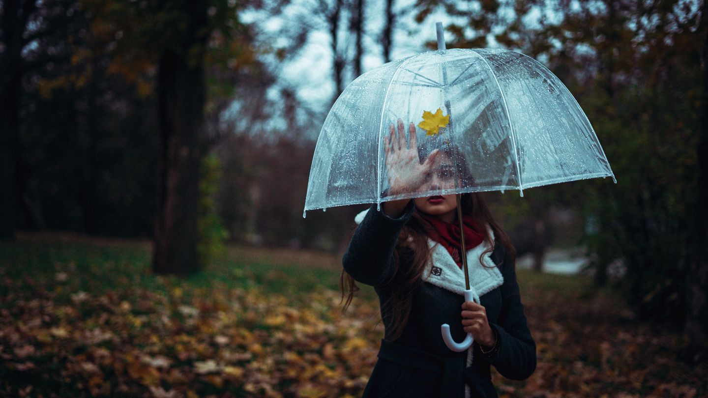Ein Mädchen mit einem Regenschirm in Park
