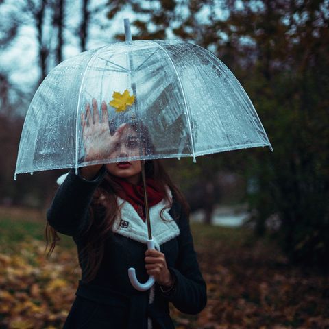 Ein Mädchen mit einem Regenschirm in Park