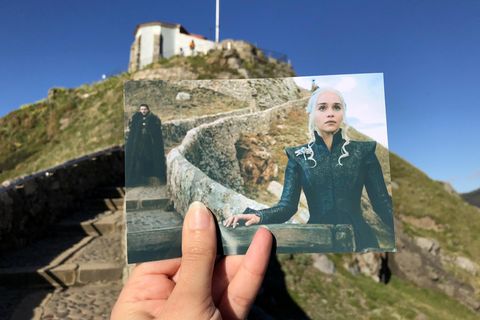  San Juan de Gaztelugatxe in Spanien: Filmtouristin Andrea David hält ein Foto mit einer Szene aus der Serie "Game of Thrones" (HBO) in die Kamera. Im Hintergrund ist der Original-Drehort zu sehen. 